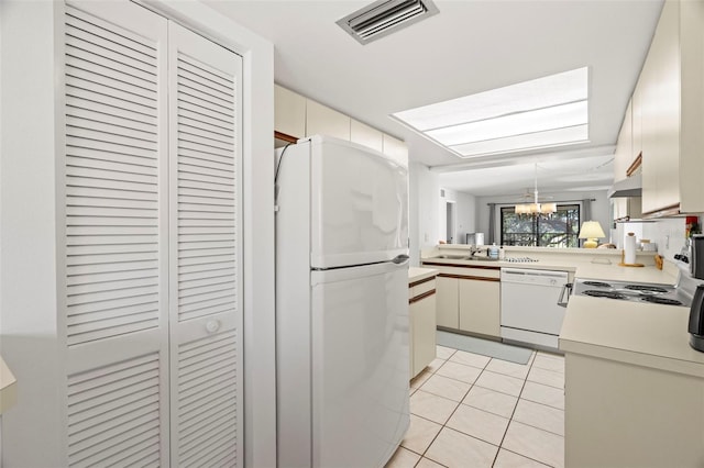 kitchen featuring visible vents, white appliances, light countertops, light tile patterned floors, and a chandelier