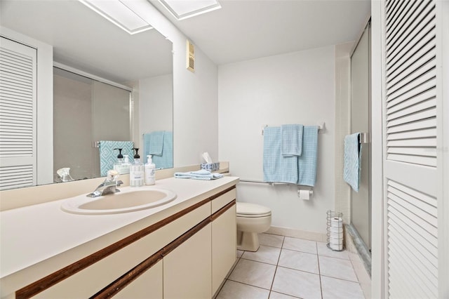 bathroom featuring vanity, a shower stall, a closet, tile patterned floors, and toilet