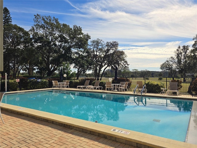 pool with a patio and fence