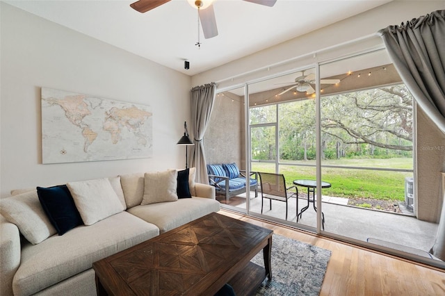 living area with ceiling fan, wood finished floors, and a sunroom