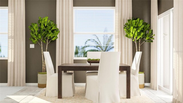 tiled dining room featuring baseboards