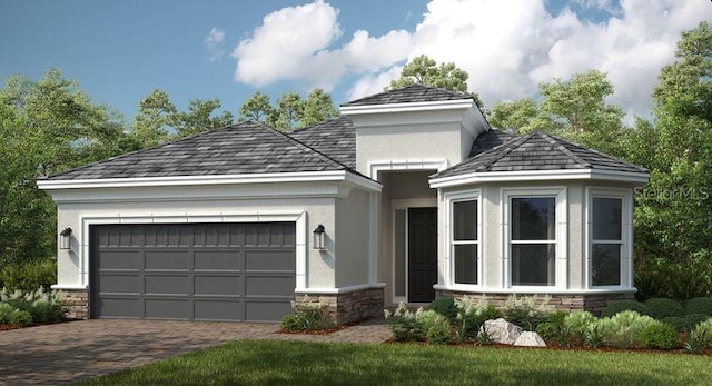 view of front of property with stone siding, stucco siding, an attached garage, and decorative driveway