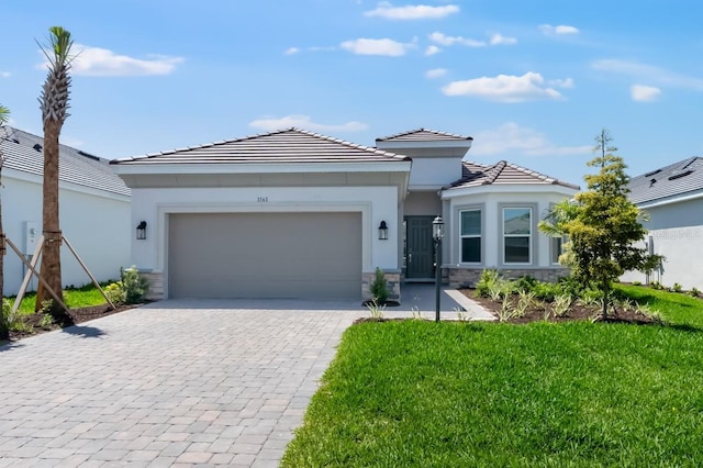 3563 Santa Caterina Blvd, Bradenton, FL 34211 - view of front of property featuring a garage, stucco siding, stone siding, and decorative driveway