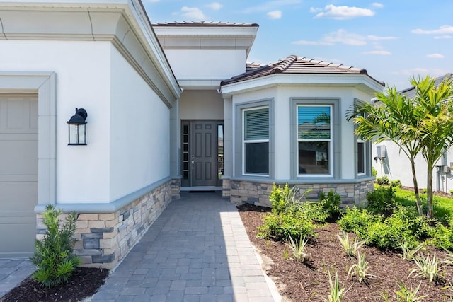 3563 Santa Caterina Blvd, Bradenton, FL 34211 - entrance to property with stone siding, a tiled roof, and stucco siding