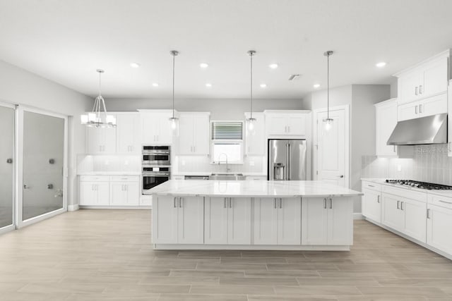 3563 Santa Caterina Blvd, Bradenton, FL 34211 - kitchen featuring stainless steel appliances, a spacious island, recessed lighting, decorative backsplash, and under cabinet range hood