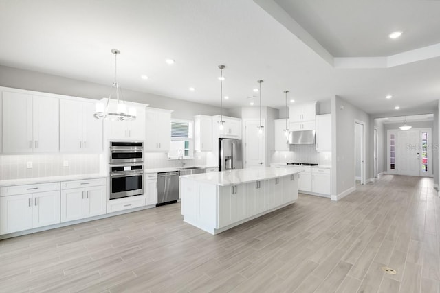 3563 Santa Caterina Blvd, Bradenton, FL 34211 - kitchen featuring under cabinet range hood, light countertops, backsplash, a sink, and appliances with stainless steel finishes