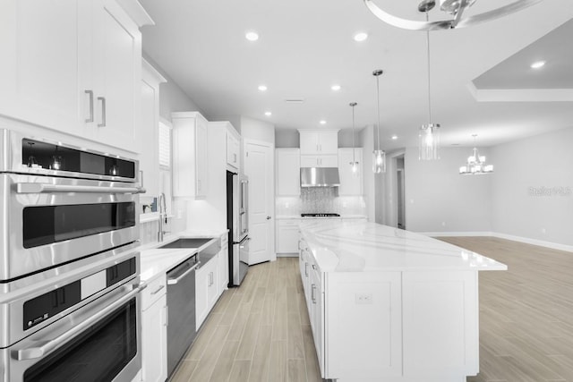 3563 Santa Caterina Blvd, Bradenton, FL 34211 - kitchen with stainless steel appliances, a center island, a sink, backsplash, and under cabinet range hood