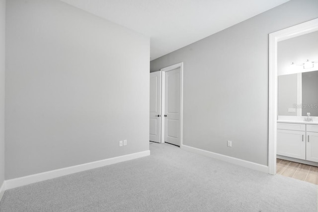 3563 Santa Caterina Blvd, Bradenton, FL 34211 - unfurnished bedroom featuring baseboards, ensuite bath, and light colored carpet