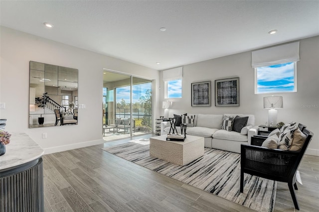 living area featuring recessed lighting, baseboards, and wood finished floors