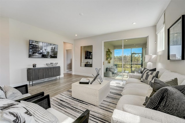 living room with recessed lighting, light wood-type flooring, and baseboards