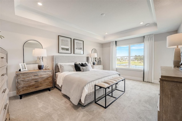 bedroom with a raised ceiling, recessed lighting, baseboards, and light carpet