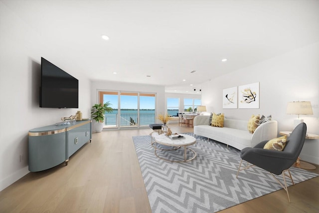 living area featuring recessed lighting, baseboards, and light wood-style floors