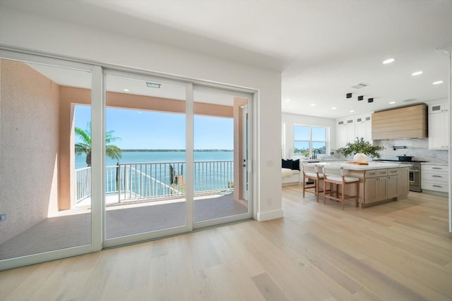 interior space with visible vents, recessed lighting, light wood-style floors, and a water view