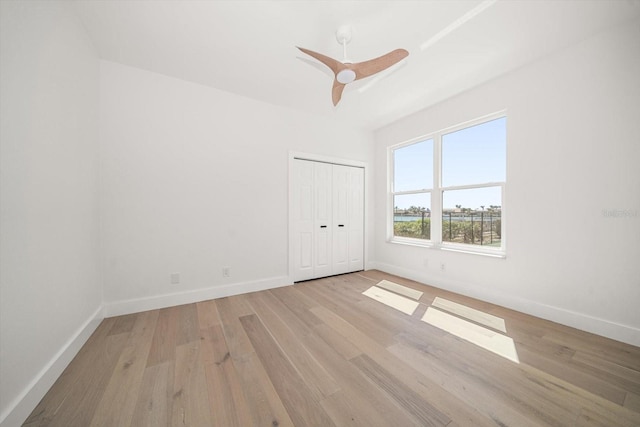 spare room featuring baseboards, light wood-style flooring, and a ceiling fan