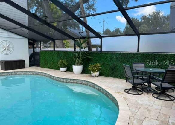 outdoor pool with a patio and a lanai