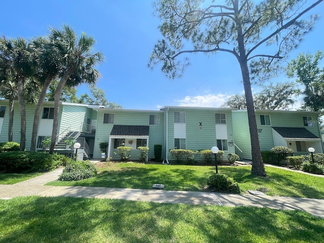 multi unit property featuring a front lawn and stairway