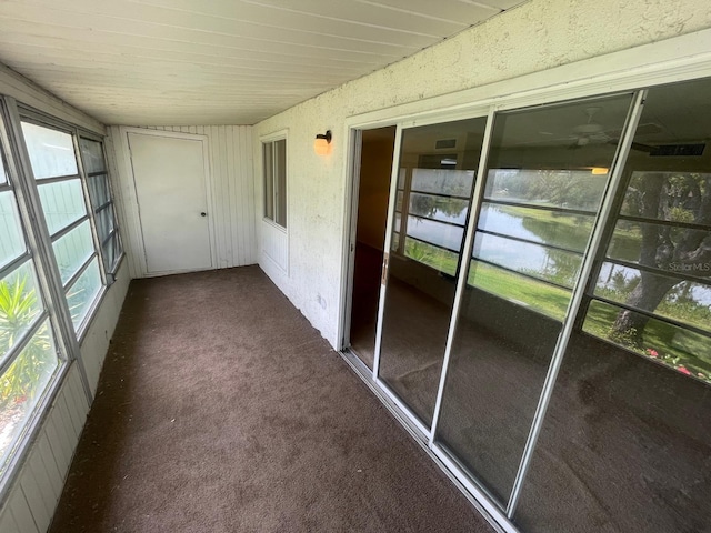 unfurnished sunroom featuring a water view