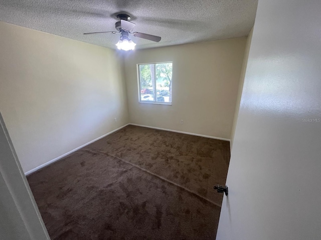 carpeted empty room with ceiling fan, a textured ceiling, and baseboards