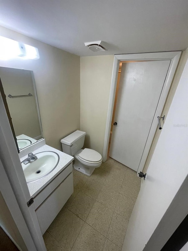 bathroom with vanity, tile patterned floors, and toilet