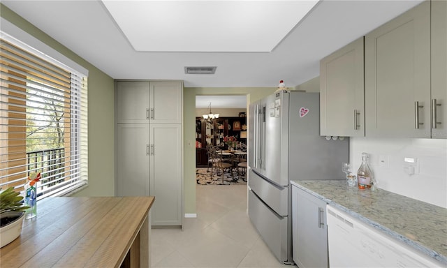 kitchen with visible vents, a notable chandelier, high quality fridge, light stone countertops, and dishwasher