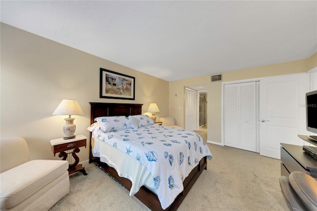 bedroom featuring a closet, light carpet, baseboards, and visible vents