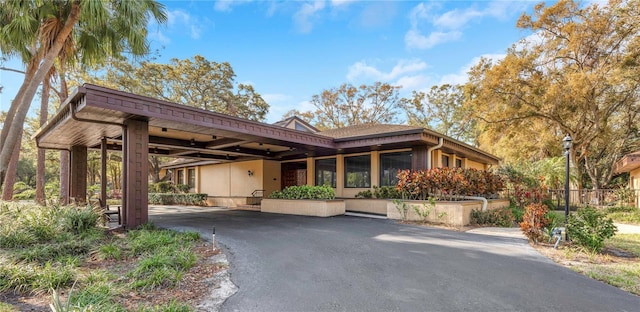 exterior space featuring an attached carport and aphalt driveway