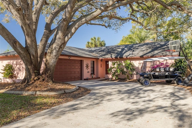 view of front facade featuring stucco siding, an attached garage, and driveway