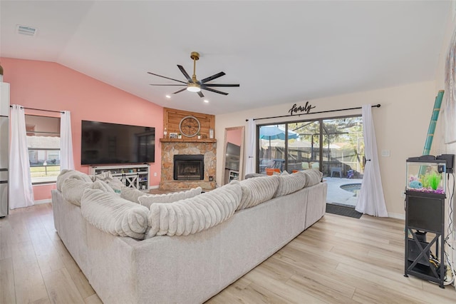 living room featuring light wood finished floors, plenty of natural light, lofted ceiling, and a ceiling fan