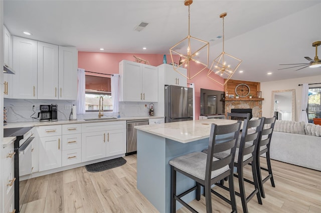 kitchen with a sink, stainless steel appliances, a wealth of natural light, and open floor plan