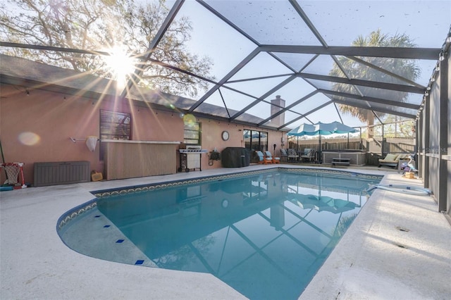 pool featuring grilling area, a hot tub, a lanai, and a patio area