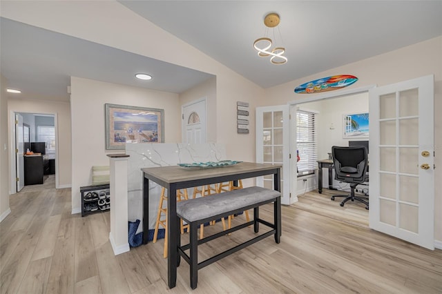 dining area featuring light wood finished floors, french doors, baseboards, and lofted ceiling