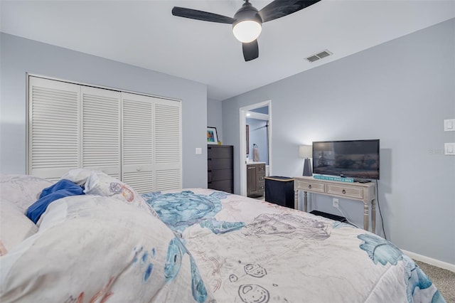 carpeted bedroom featuring visible vents, connected bathroom, a closet, baseboards, and ceiling fan