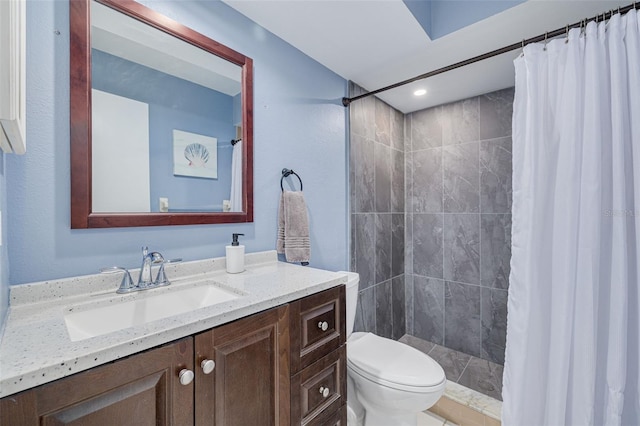 bathroom with tiled shower, toilet, and vanity