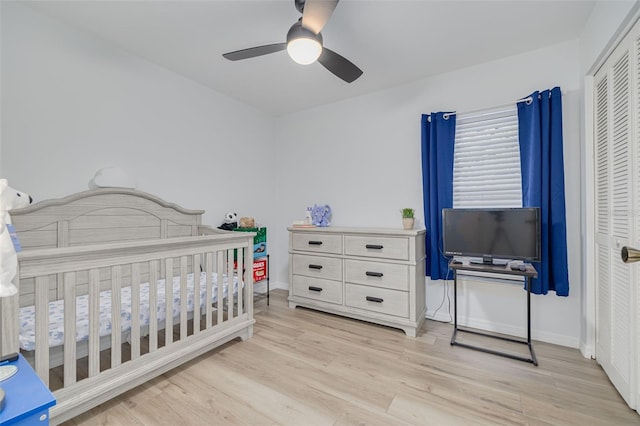 bedroom featuring a closet, light wood-style flooring, a ceiling fan, and baseboards