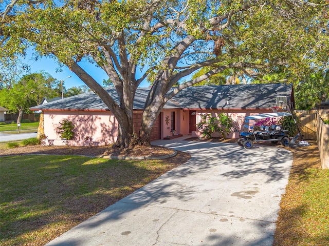 view of front of house featuring a front yard, driveway, and fence