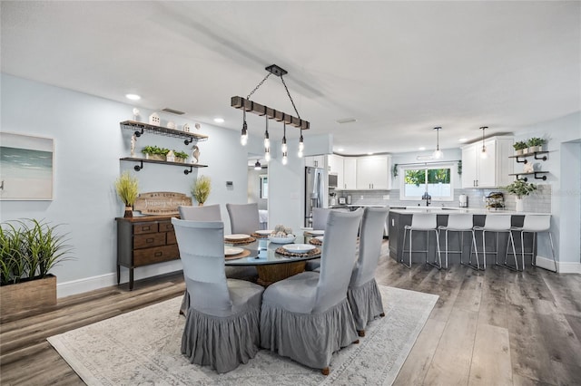 dining space featuring recessed lighting, baseboards, and wood finished floors