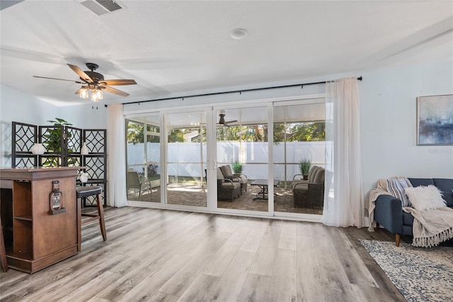 interior space featuring ceiling fan, visible vents, and wood finished floors