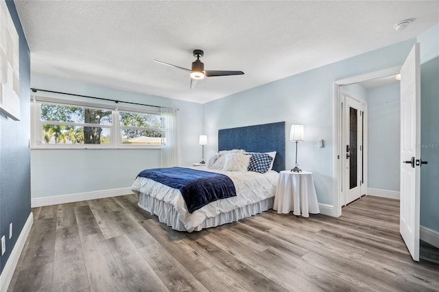 bedroom featuring a ceiling fan, wood finished floors, and baseboards