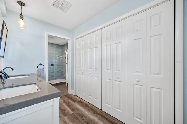 full bathroom featuring visible vents, wood finished floors, a closet, and a stall shower