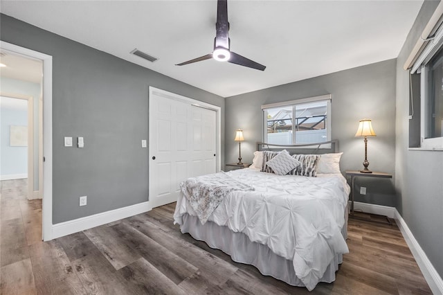 bedroom featuring a closet, visible vents, baseboards, and wood finished floors