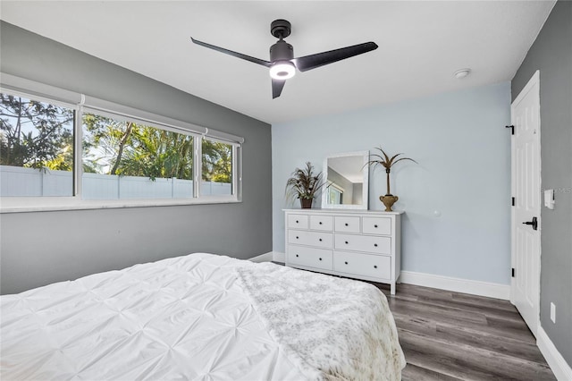 bedroom with ceiling fan, baseboards, and dark wood-style floors