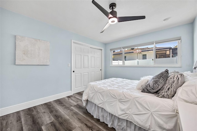 bedroom featuring dark wood finished floors, a ceiling fan, baseboards, and a closet