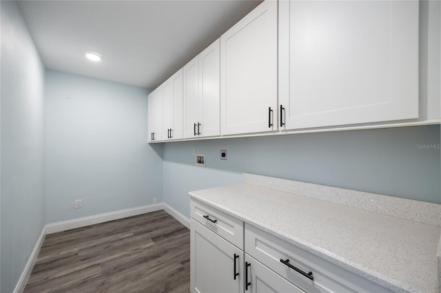 washroom featuring cabinet space, baseboards, dark wood-style flooring, and electric dryer hookup