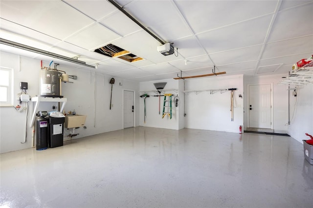 garage featuring electric water heater, a garage door opener, and a sink