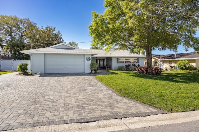 ranch-style house featuring stucco siding, a front lawn, decorative driveway, fence, and a garage