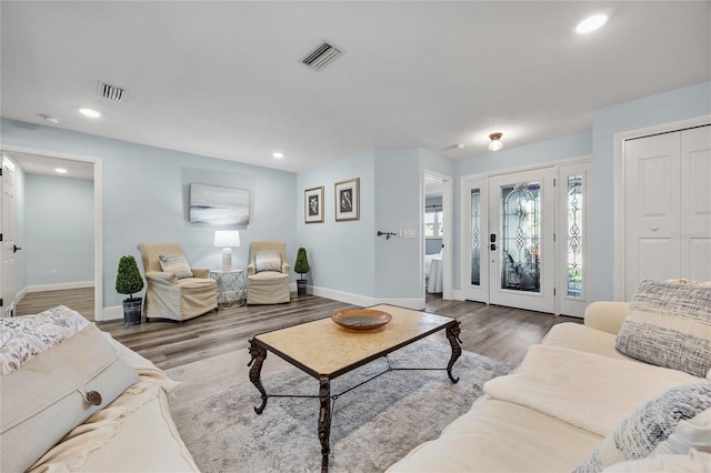 living area featuring visible vents, recessed lighting, baseboards, and wood finished floors