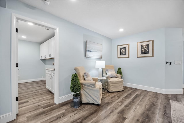 living area with recessed lighting, baseboards, and wood finished floors