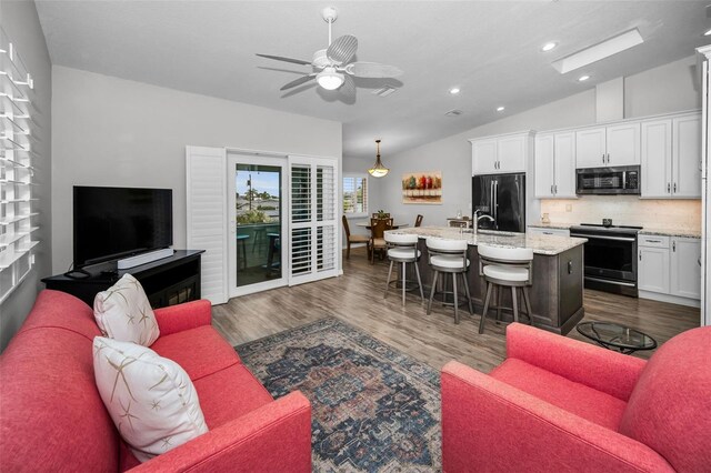 living room featuring dark wood-style floors, recessed lighting, ceiling fan, and lofted ceiling