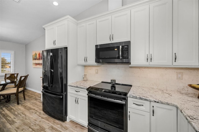 kitchen featuring tasteful backsplash, white cabinetry, black appliances, and light wood-style floors