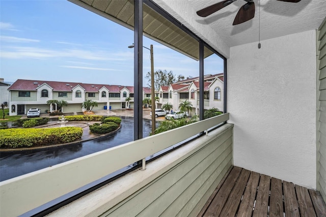 balcony with a residential view and a ceiling fan